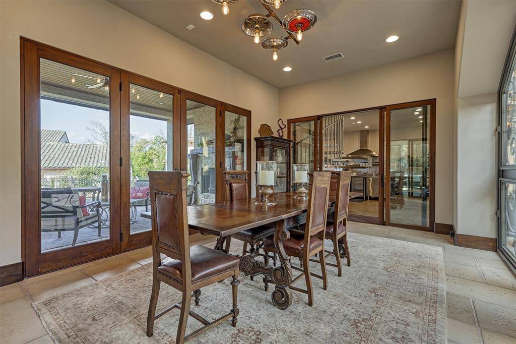 Dining room connects to kitchen, gathering room, covered patio, and  motor court, creating a harmonious flow ideal for entertaining .