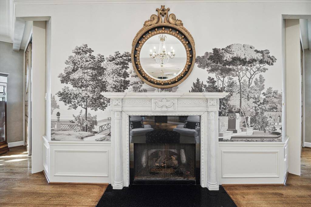 The stately fireplace surrounded by Zuber’s scenic Les Jardins Francais wallpaper creates a stunning focal point in the home’s inviting living spaces. Warm yourself in front of the gas-log fireplace featuring a breathtaking marble mantelpiece sourced from the John O’Quinn estate.