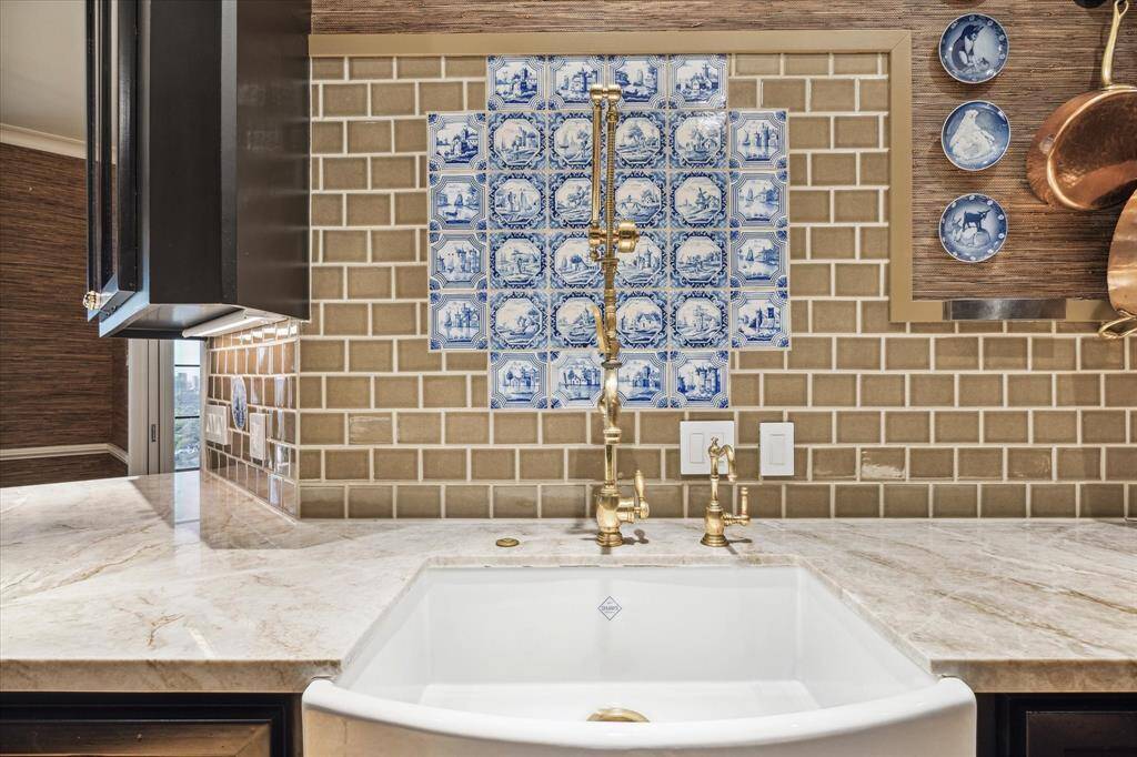 In the gourmet kitchen, glazed subway tile melds beautifully with Taj Mahal quartzite countertops and inset antique Delft tile.