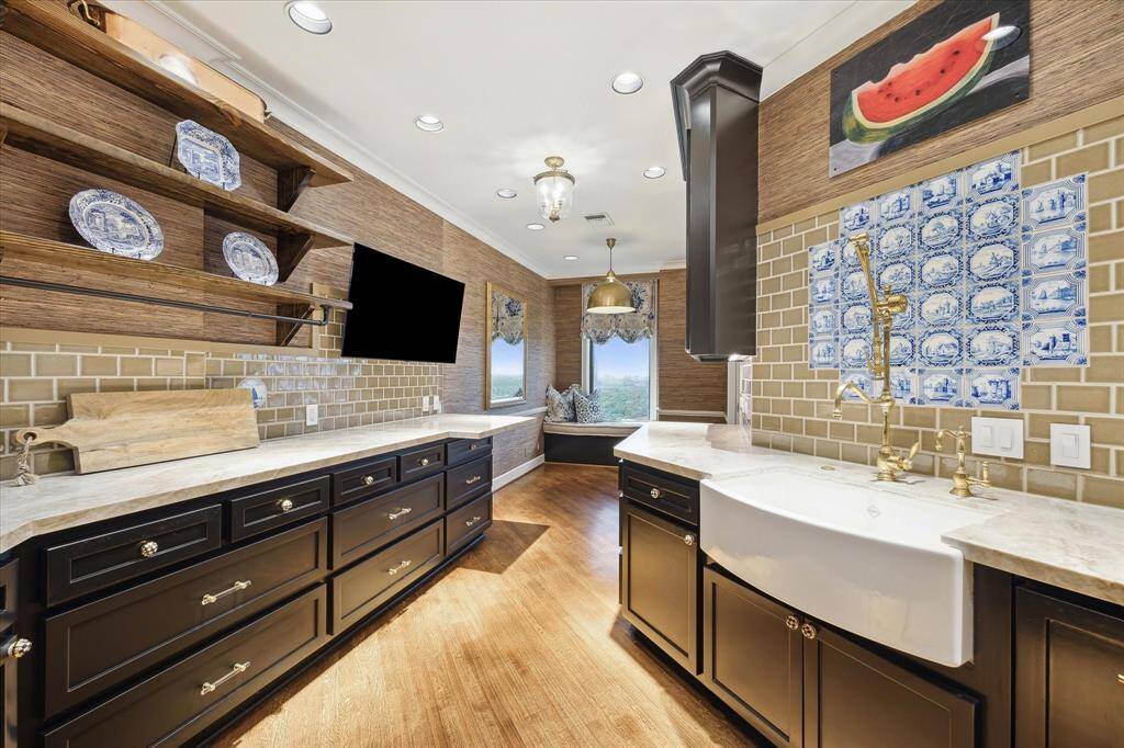 A wall-mounted knife block, television and a walk-in pantry with a beverage center add convenience to the work-of-art kitchen.