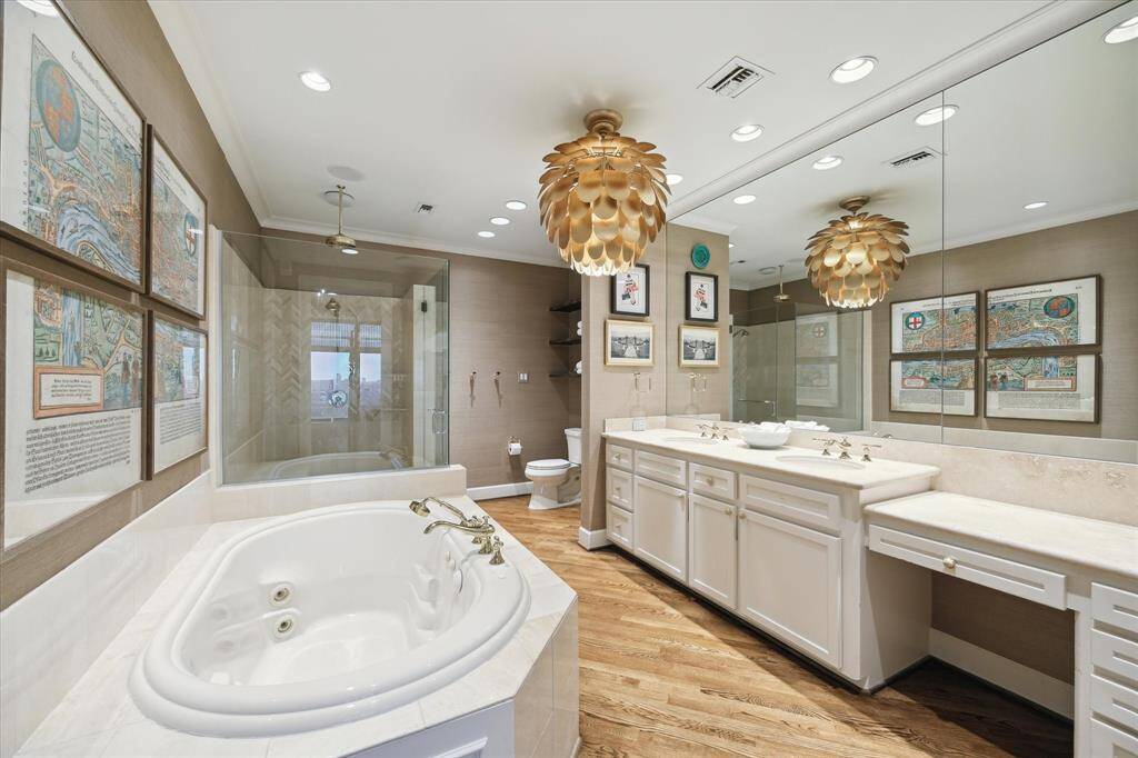 Relax and unwind in the beautiful owner’s bathroom anchored by a wide double vanity featuring MacKenzie-Childs hardware and a knee space. Designer and recessed lighting provides ideal illumination.