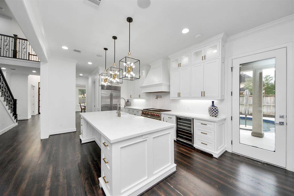 The kitchen also offers designer pendant lighting, a wine fridge, under-cabinet lighting and direct pool area access!