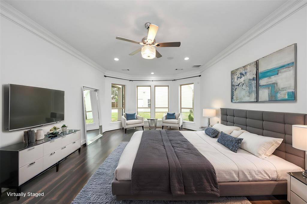 The primary suite leaves nothing to be desired - note the wonderful bay window seating area, lovely crown molding details, surround sound and elegant chandelier fanlight fixture!