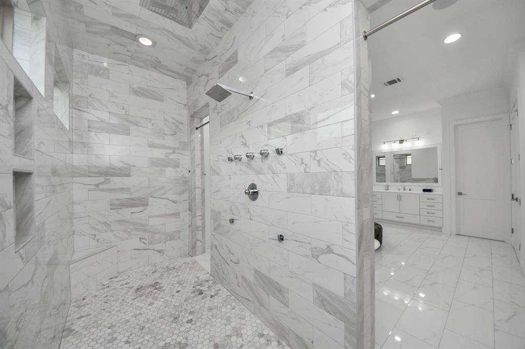 You'll enjoy a spa-like experience in this exquisite and elegant custom showering area with multiple body jets and dual entrances!