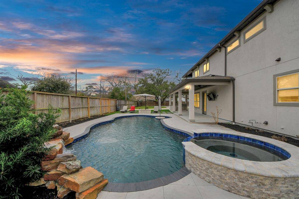 The gorgeous, heated waterfall pool is 6' deep and includes a heated spa and an in-water seating area with table and umbrella!