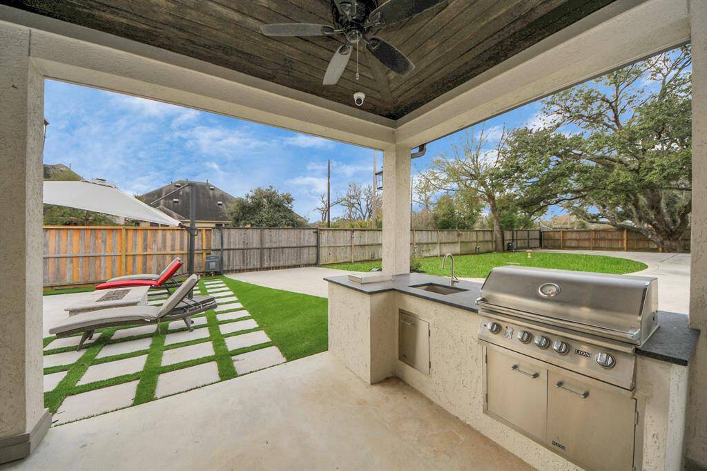 The outdoor kitchen area is conveniently just steps from the pool! Featuring a sink, gas range, a TV and a spacious covered seating area, this is the perfect place for outdoor gatherings with family and friends!