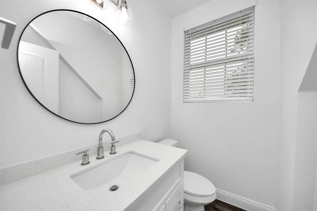 The garage apartment guest bathroom offers quartz counters, ample storage and a nice window for natural light!
