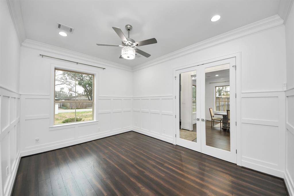 Adjacent to the entryway and across from the dining area is this wonderful 14'9" x 11'11" office/study with French doors and extensive wainscoting!