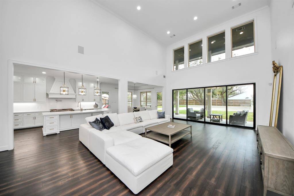 Upon entering the home, you're met with soaring 20' ceilings in the living area, and the glass doors leading to the outdoor covered patio are fully retractable!