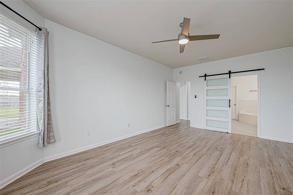 The stylish sliding barn door leads to the adjacent en-suite.