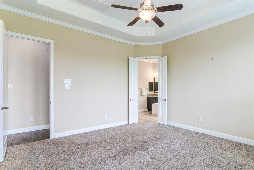 The ensuite bathroom is framed by two small French doors.