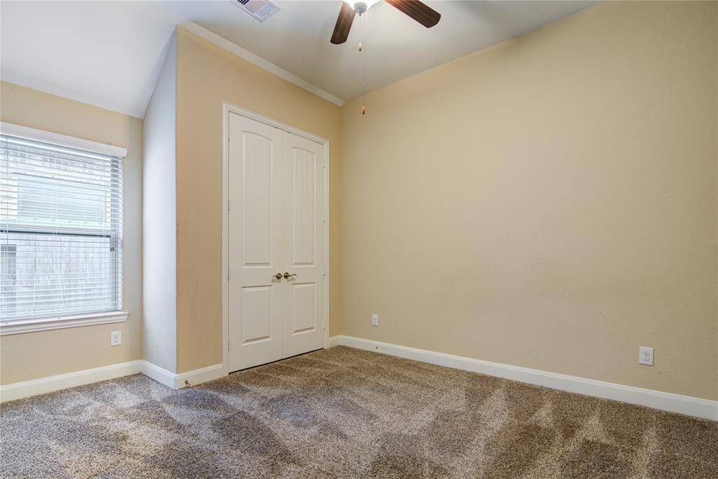 Bedroom 2 has tall ceilings and ceiling fan with light fixture.