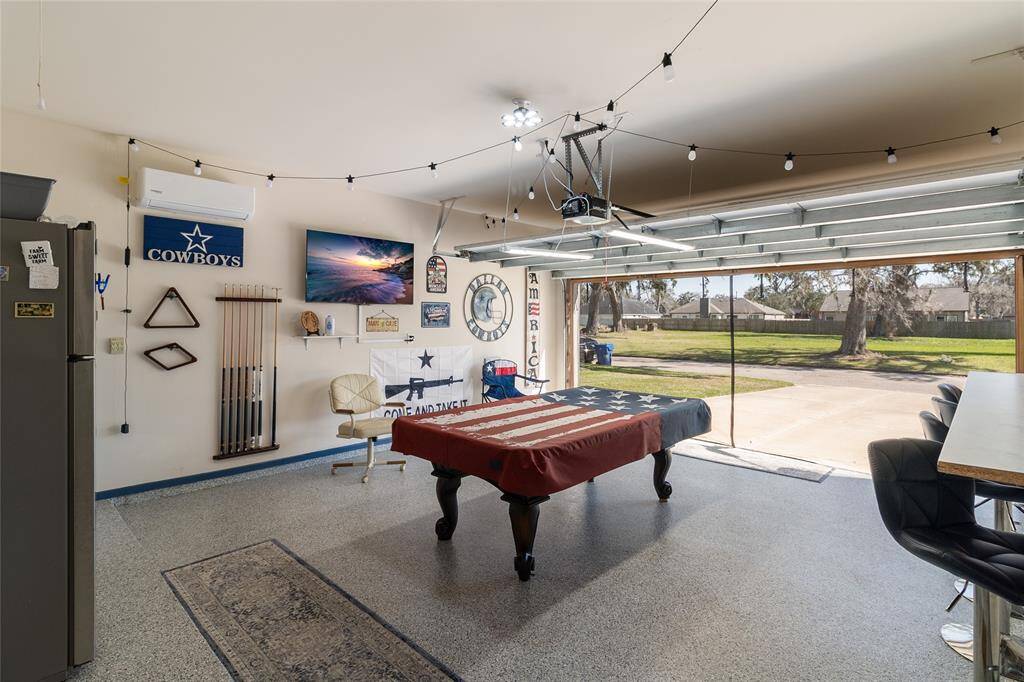 Currently utilized as an additional hangout space, this spacious garage features epoxy flooring, a shade to keep flying pests out & a mini-split HVAC system to ensure year-round enjoyment.