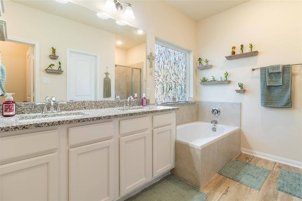 Indulge in a spa-like experience in this primary ensuite featuring a double vanity with under-mount sinks and elegant granite countertops that provide both style & functionality.