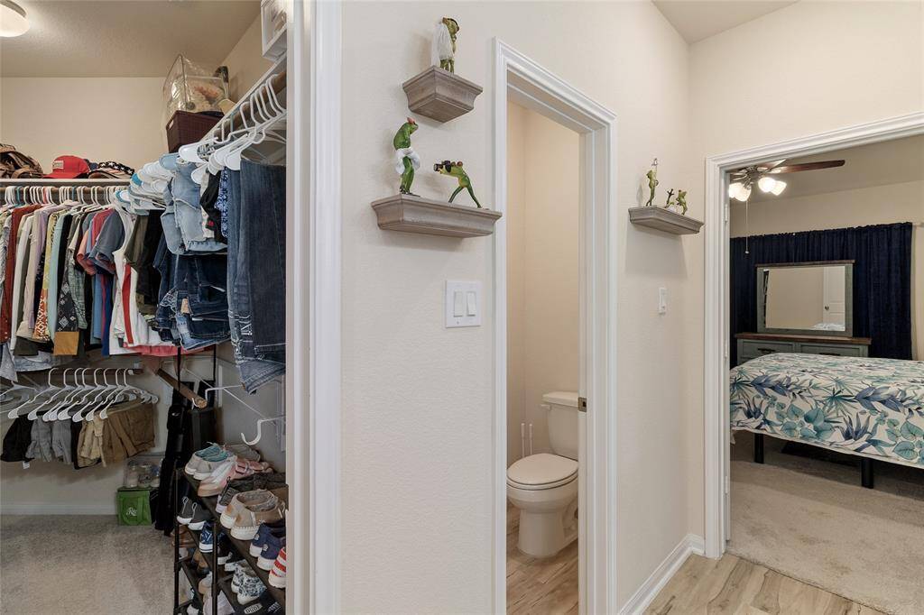 Glimpse showcasing the oversized primary walk-in closet that provides plenty of room for all your clothing & accessories, ensuring maximum organization.