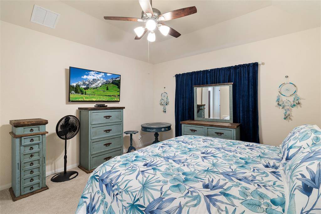 Peaceful primary bedroom with views overlooking the backyard & above-ground pool area.