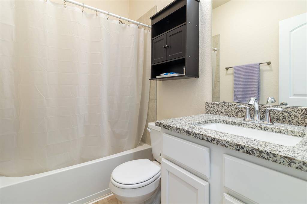 2nd full bathroom, located adjacent to Bedroom #2 and Bedroom #3, features granite countertops & a tub/shower combo with a tiled shower surround, providing convenience for loved ones and guests.