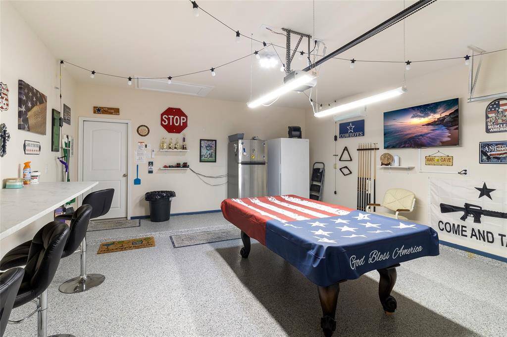 Ultimate hangout space featuring sleek epoxy flooring & plenty of room for fridges or freezers. It's the perfect spot to entertain, making it more than just a garage – it's a true retreat!
