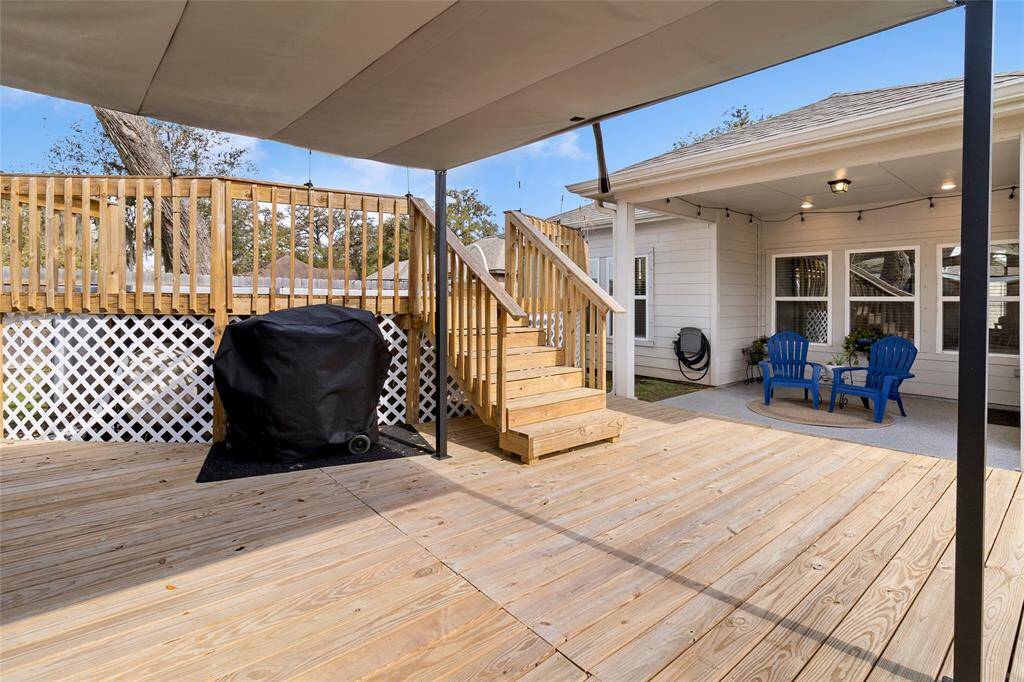 Enjoy the outdoors in comfort with the second covered space on the added wooden deck, featuring a retractable shade for optimal sun protection.