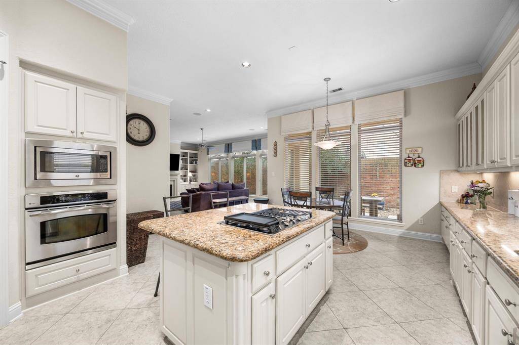 This look at the kitchen provides a glimpse of the huge windows at the back of the home that provide incredible natural light. The covered back patio is accessible from the breakfast area.