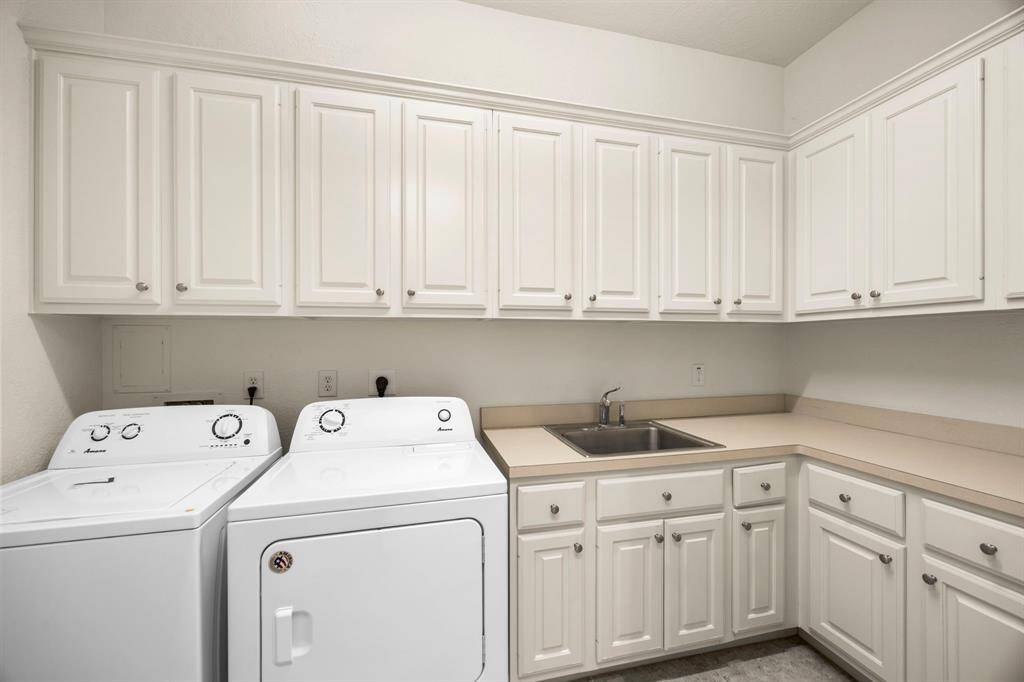 After making your way up the extra wide staircase the first room you encounter at the second floor landing is the huge utility room complete with incredible storage, counter space & sink.