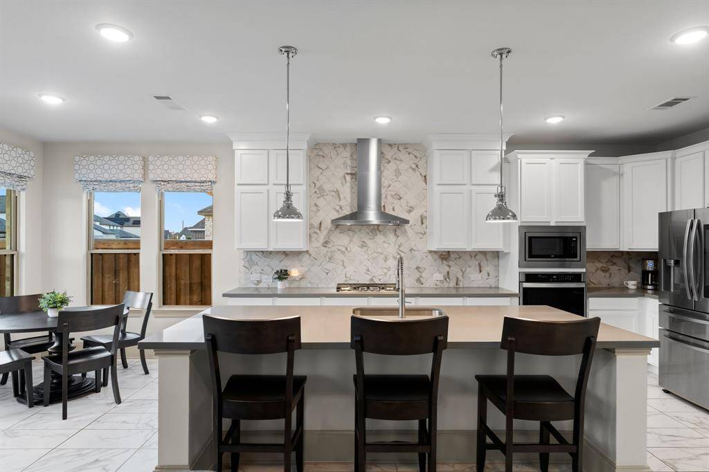 Quartz counters and stylish backsplash add a touch of elegance.