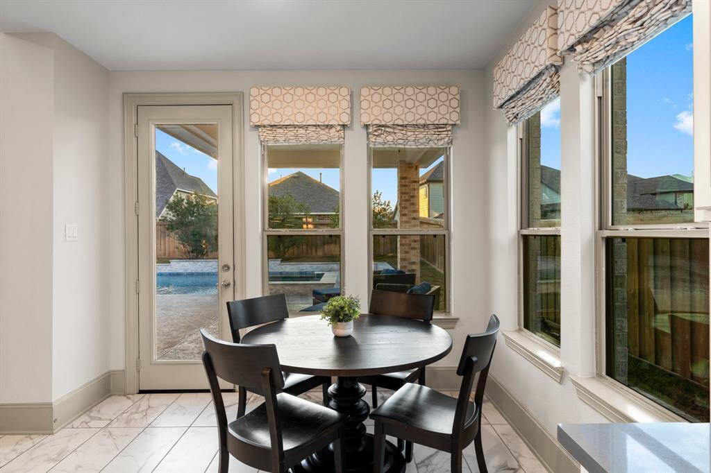 Cozy breakfast nook with large windows overlooking the sparkling pool.