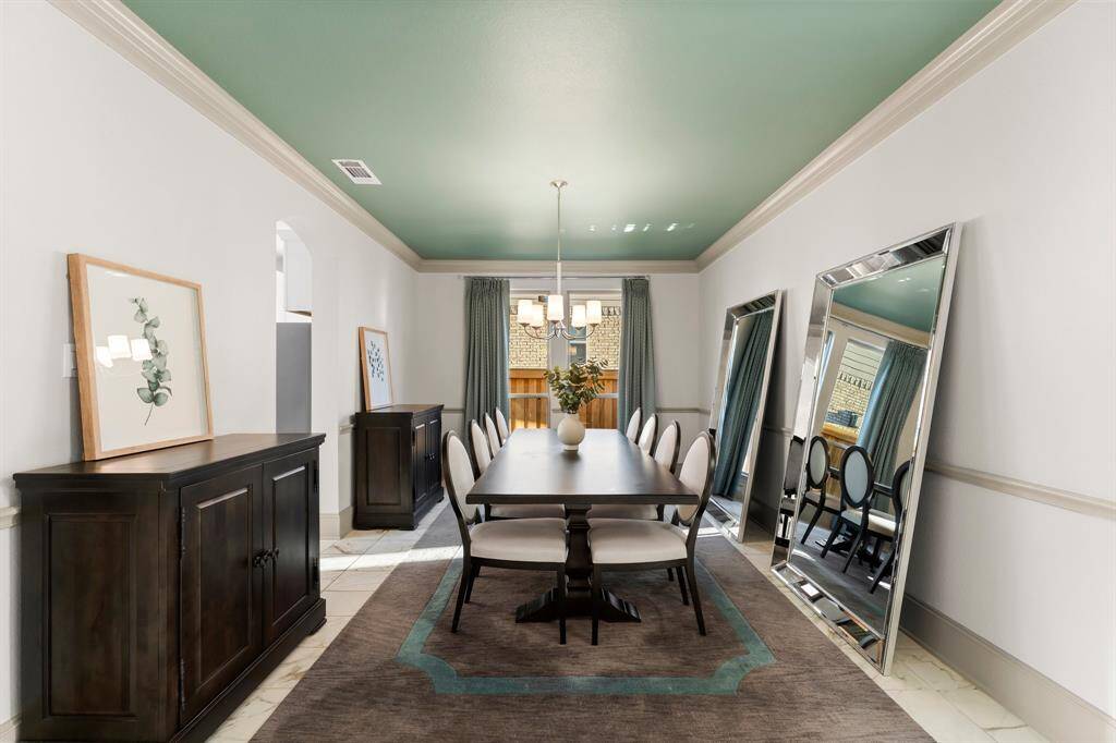Kitchen leads to elegant formal dining room with custom drapes