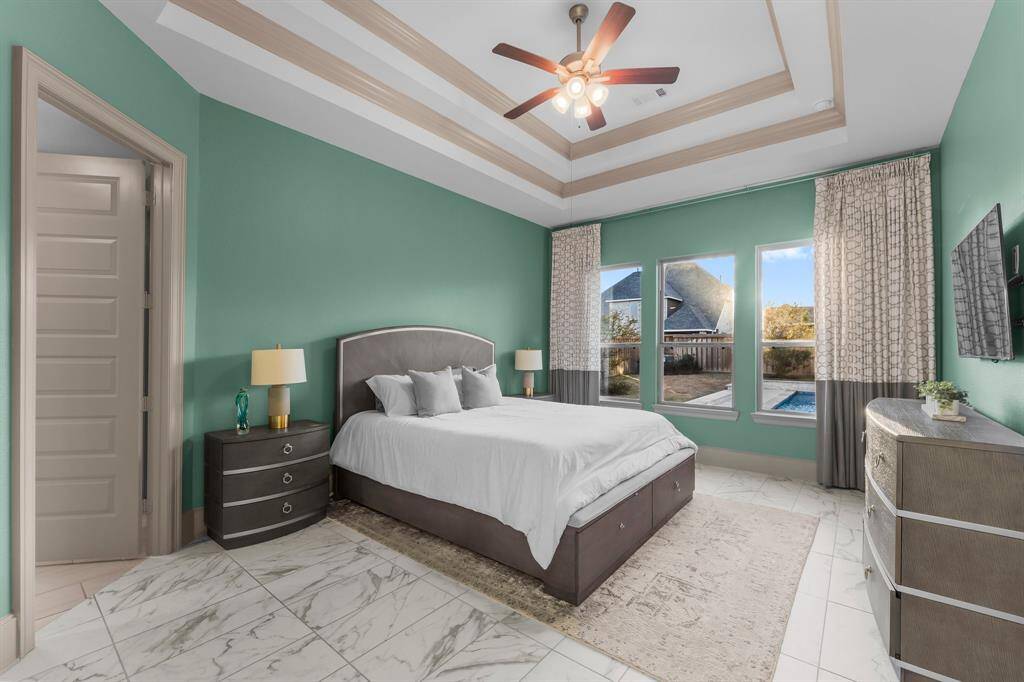 Luxurious primary bedroom with serene pool views.