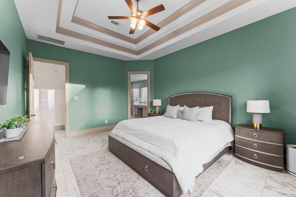 Primary bed leads to primary bath that has separate his and hers closets.