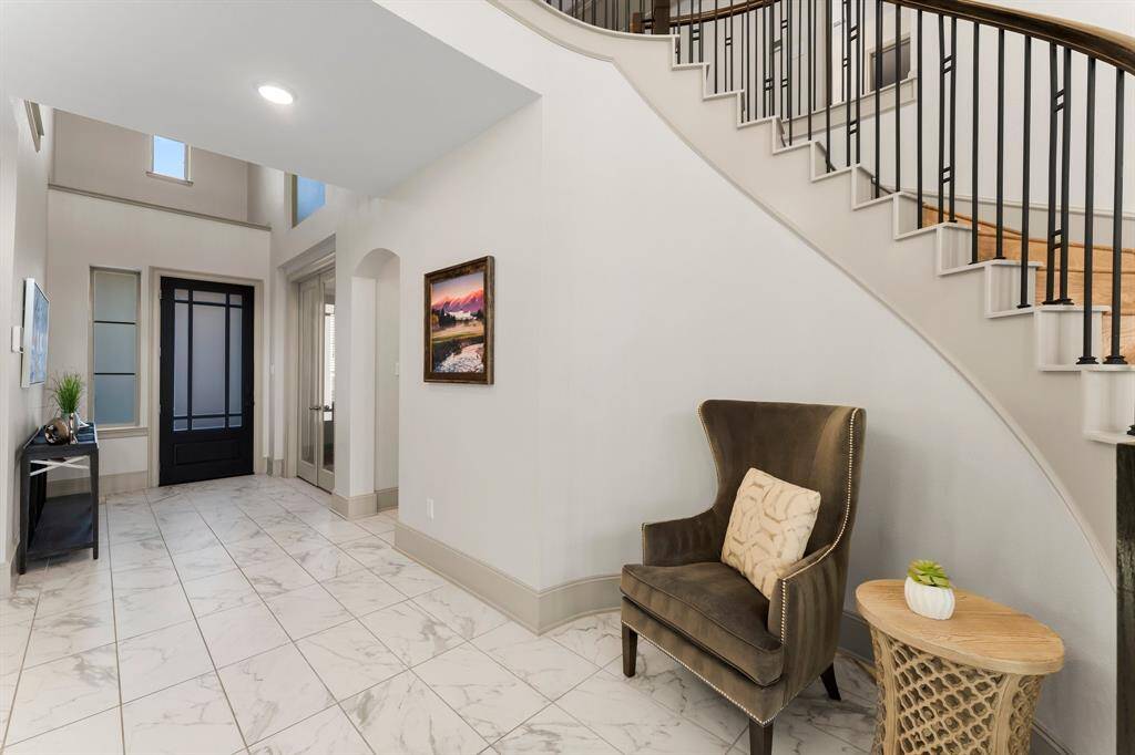 Grand curved staircase with tall ceilings.