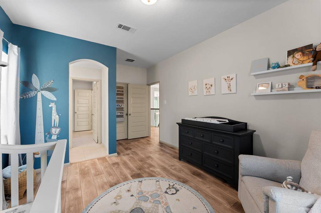 Light LVT flooring complements the soft, neutral walls, creating a welcoming atmosphere.