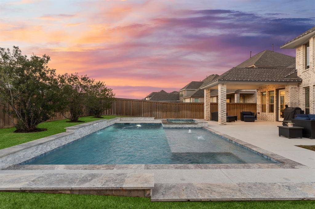 Relax in your private oasis featuring a sparkling pool, soothing spa, and a spacious covered patio perfect for entertaining.