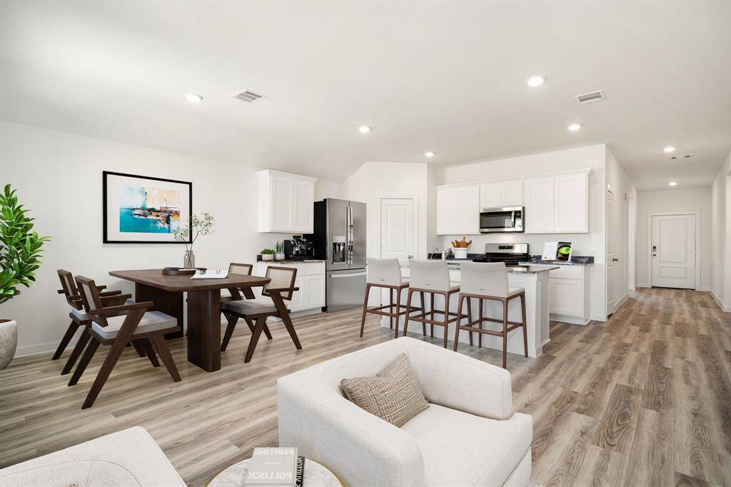 Step into this beautifully designed open-concept living space, where modern elegance meets everyday comfort. The bright and airy kitchen features crisp white cabinetry, sleek granite countertops, and stainless steel appliances, seamlessly flowing into the inviting dining and living areas. Luxury vinyl plank flooring enhances the warmth and sophistication of the space, while recessed lighting adds a stylish touch. A spacious layout and neutral color palette create a perfect canvas for any décor style.
