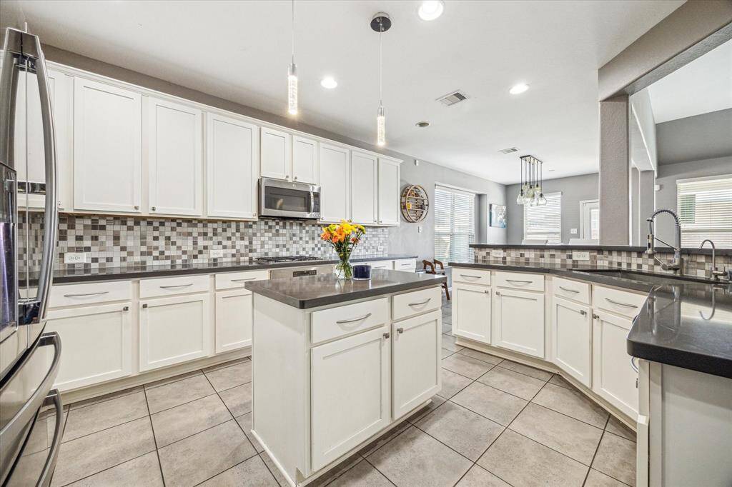 The kitchen is open, bright, and offers plenty of cabinet space, a center island, and a walk-in pantry