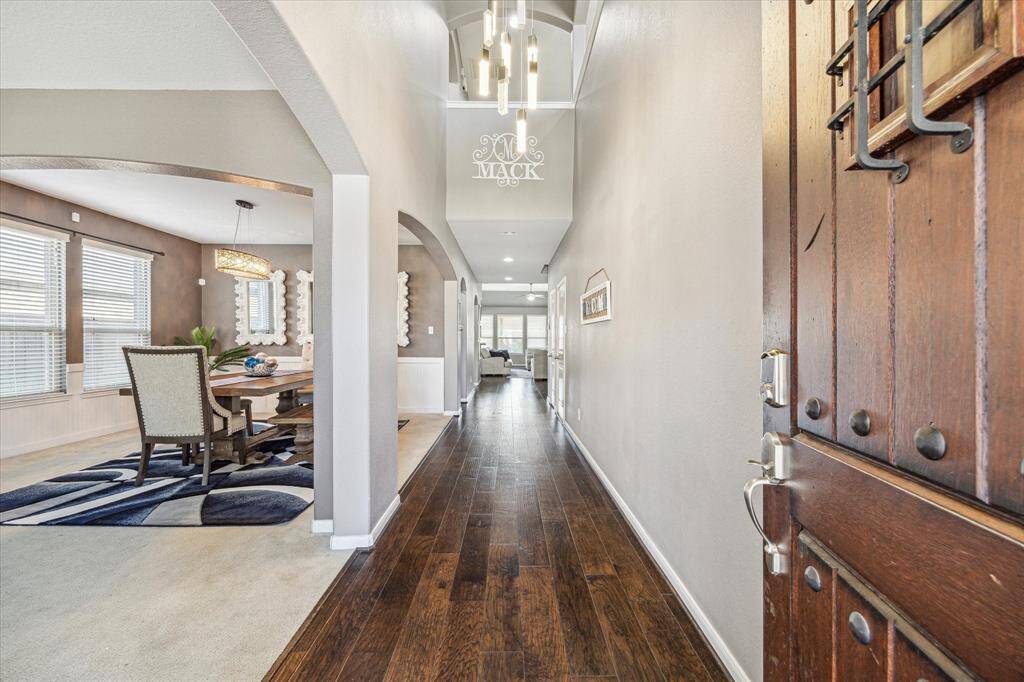 A grand entrance with soaring ceilings and hardwood floors