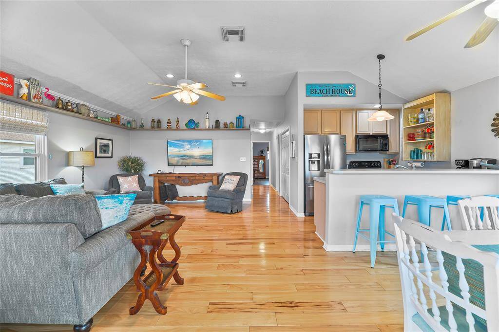 The open concept living area features vaulted ceilings, and hardwood floors.