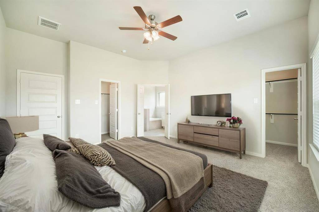 Wake up to gorgeous backyard views in this expansive primary suite! Featuring plush carpeting, a ceiling fan, and abundant natural light, this space is designed for both comfort and style. The ensuite bath and walk-in closet are just steps away, offering both luxury and convenience in your private retreat.