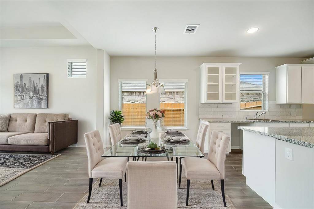 Enjoy meals in this sun-filled dining area, where large windows bring in natural light and backyard views. The elegant pendant lighting adds a stylish touch, while the open layout ensures a seamless connection to the kitchen and living areas. Perfect for intimate dinners or lively gatherings.