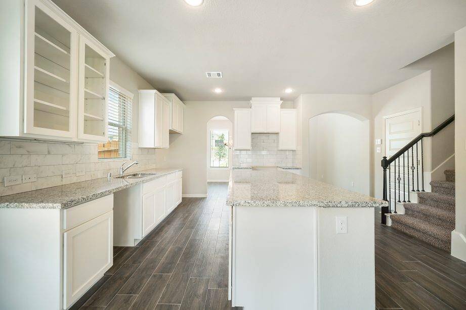 Experience the perfect blend of style and functionality in this open floor plan. The kitchen flows effortlessly into the spacious family room, creating a seamless space for entertaining. Notable features include wrought iron stair railings, arched doorways, and neutral tones for a sophisticated yet cozy feel.