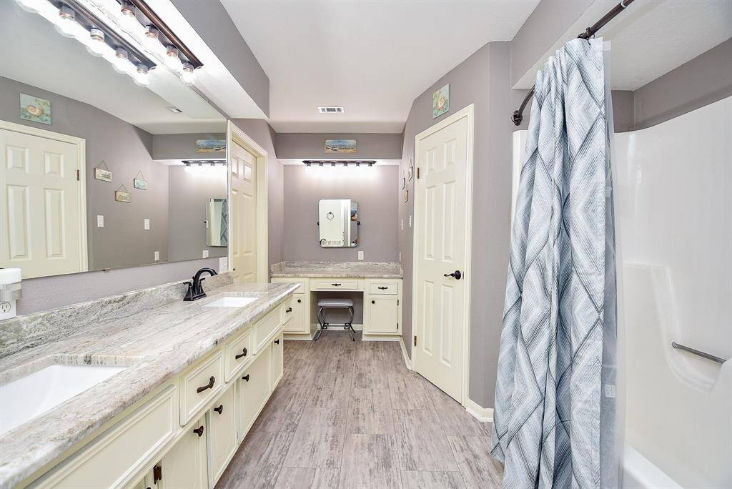 Your primary ensuite bath delivers all manner of creature comforts in convenient configurations: dual sinks, below a shining wall-wide mirror; tons of storage below; a separate vanity (up center); with combined bathtub/shower, right, for easy personal options.