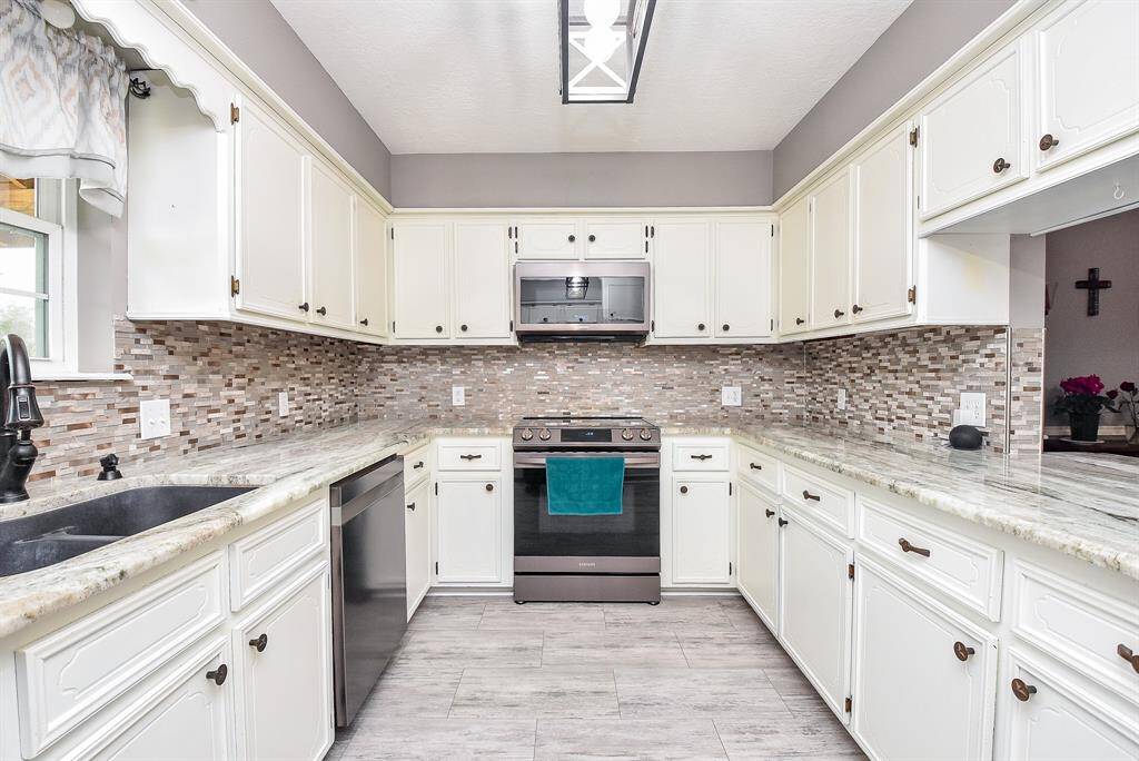 Just look at the (upgraded?) cabinetry, creamy granite counter tops, and peaceful wash of natural shades, top and bottom, to invite and activate this perfectly workable kitchen.
