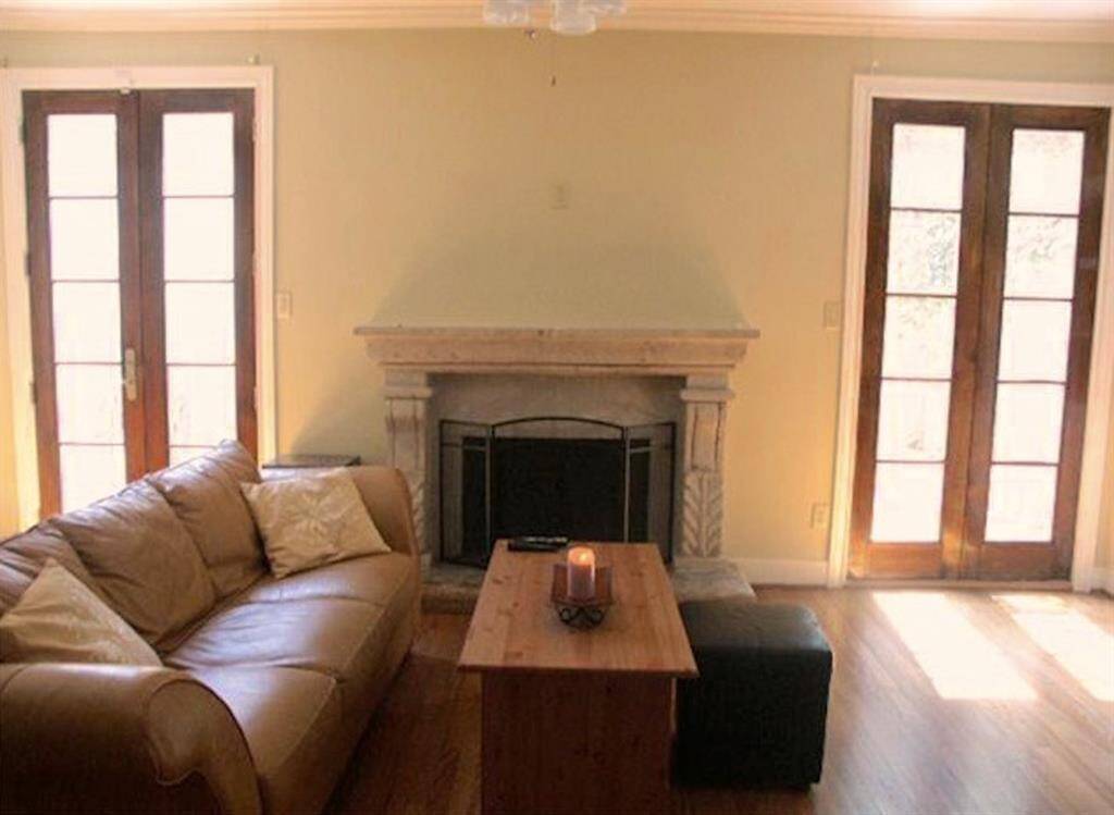 Living area fireplace is flanked by french doors leading out to the patio.