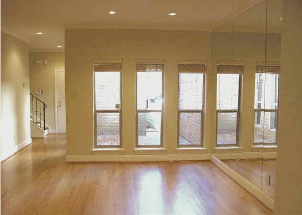 Looking from the living room toward the front of the home. Front courtyard seen through the windows.