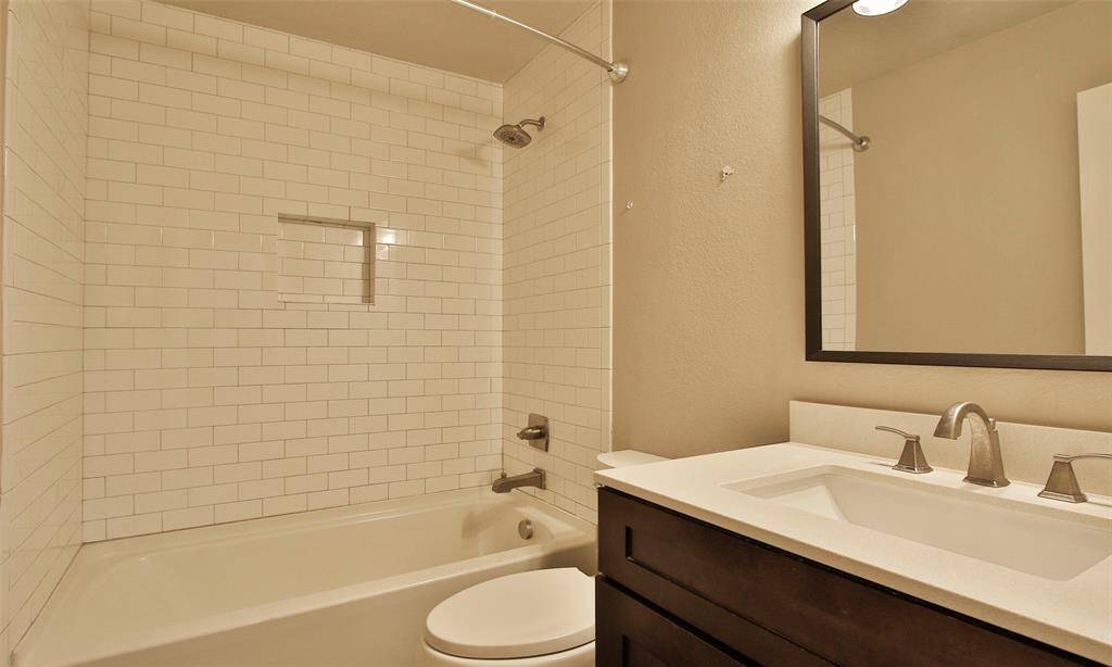 Hall Bath features tiled shower/tub combo and quartz countertops.