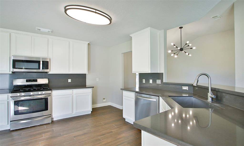 The gourmet Kitchen features stainless steel appliances, upgraded cabinets, quartz countertops, and a breakfast bar open to the Living.