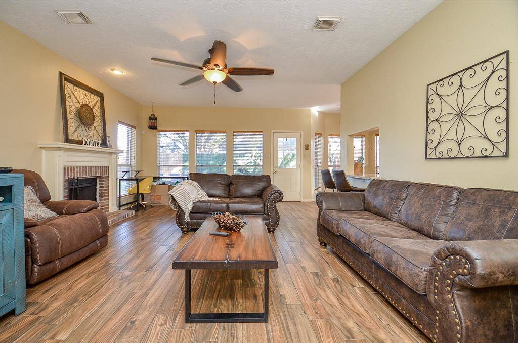 DEN W/  CEILING FAN AND GAS FIREPLACE W/ MANTLE, BRICK AND TRIM WORK.