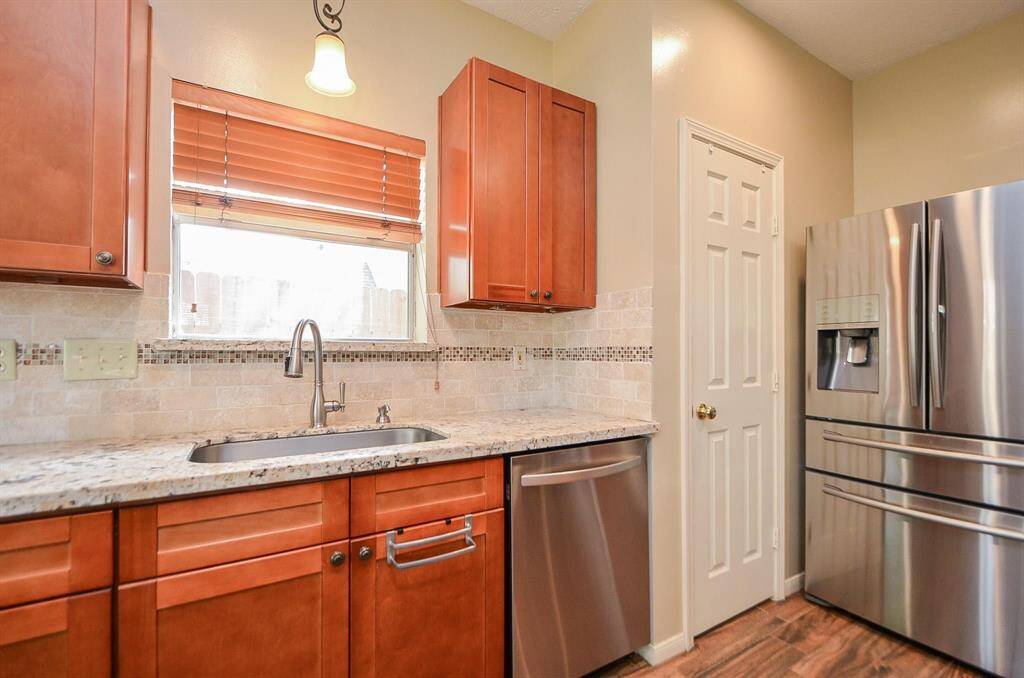 THE BLINDS MATCH THE SHAKER STYLE CABINETS WITH ADDED DOOR KNOBS.