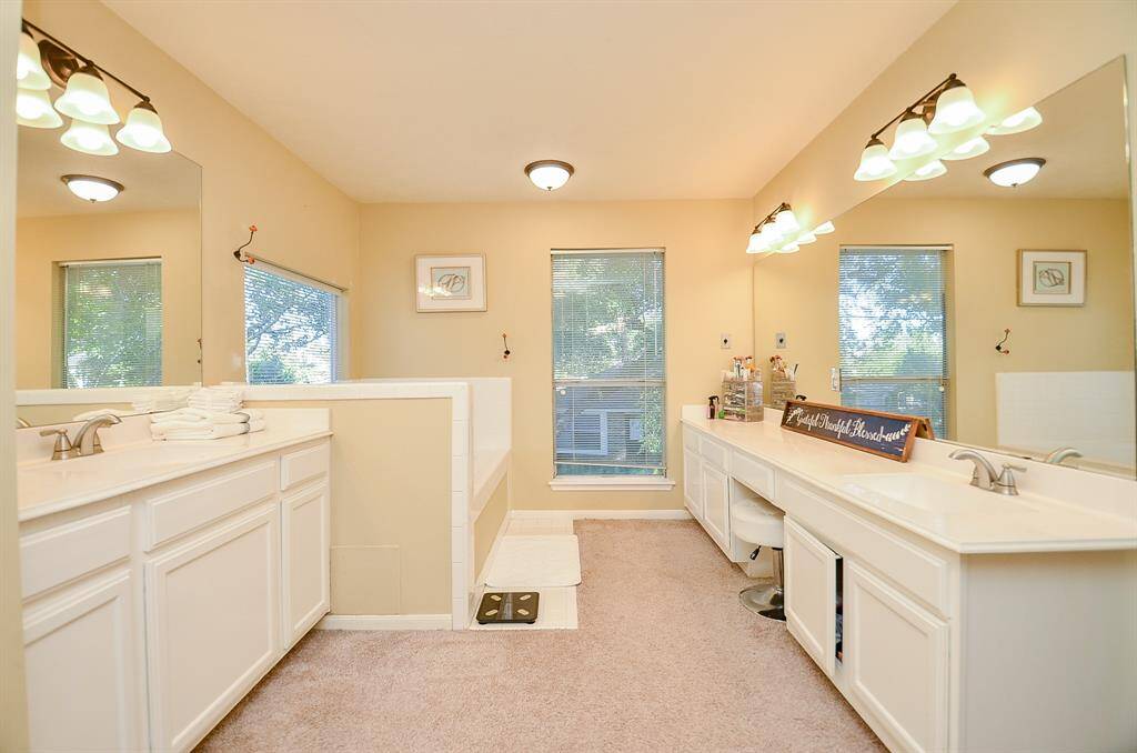 SPACIOUS MASTER BATHROOM. HIS AND HER VANITIES LOCATED ACROSS FROM EACH OTHER. UPDATED LIGHTING