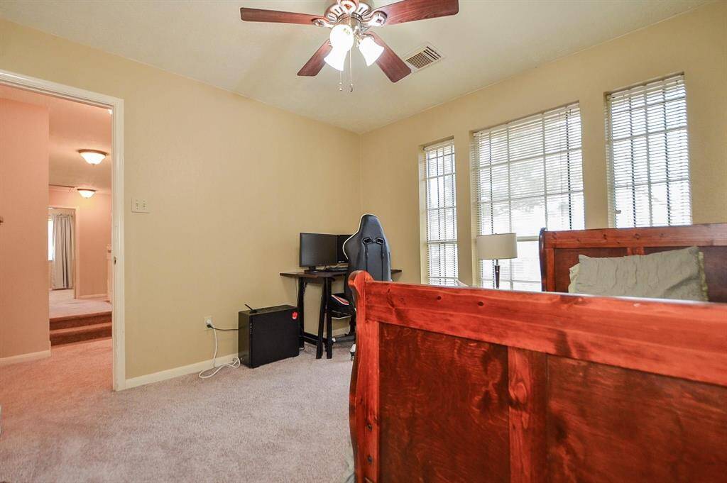 BEDROOM ON THE LEFT SIDE OF SPLIT STAIRWAY. CEILING FAN AND WALL OF WINDOWS W/ BLINDS